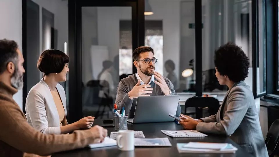 Distansarbete försämrar utvecklingsarbetet Bild på människor som har möte vid ett konferensbord. Foto: AdobeStock.