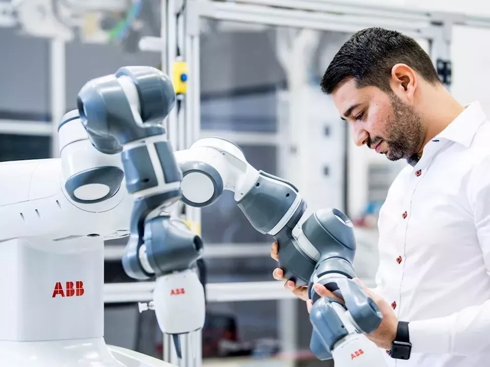 Bild på ABB-robot och en person som arbetar med den. 